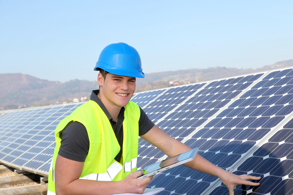 Young adult doing professional training on solar panels plant